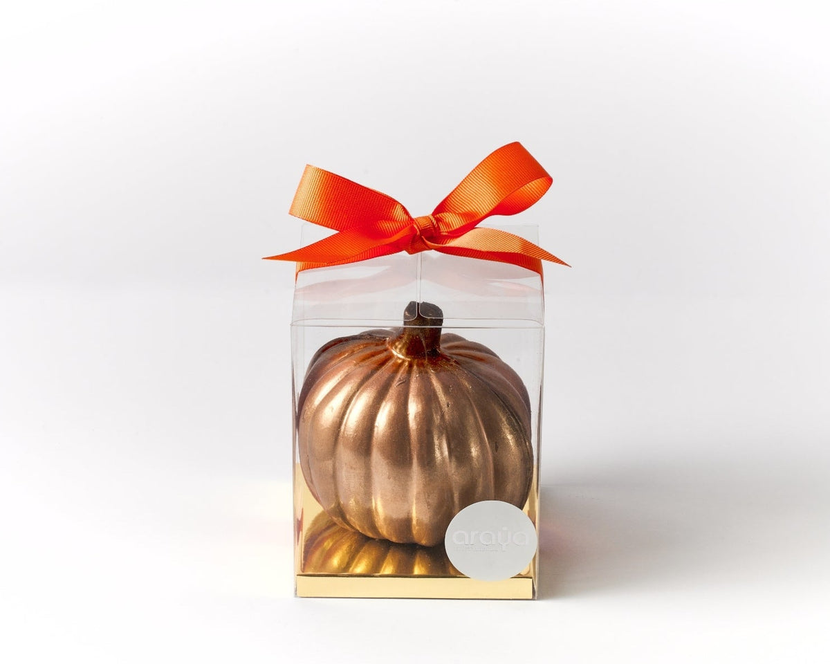 Milk chocolate pumpkin in a clear gift box with a golden base and an orange satin bow